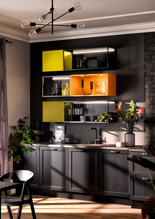 Diese Landhausküche erhält ihre ungewöhnliche Optik durch schwarze Fronten und moderne Regale im industrial Design in strahlendem Gelb und Orange.